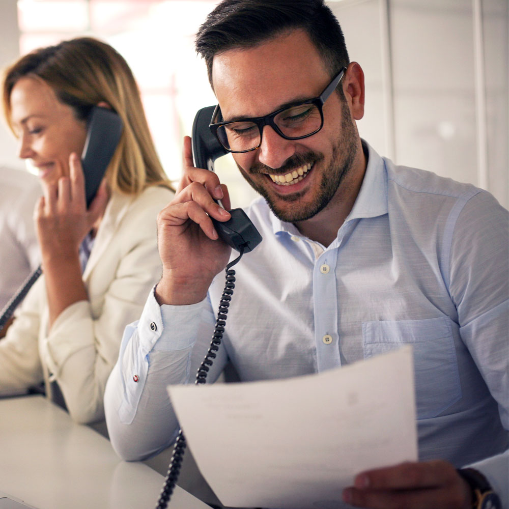 Man and woman talking and smiling on phones