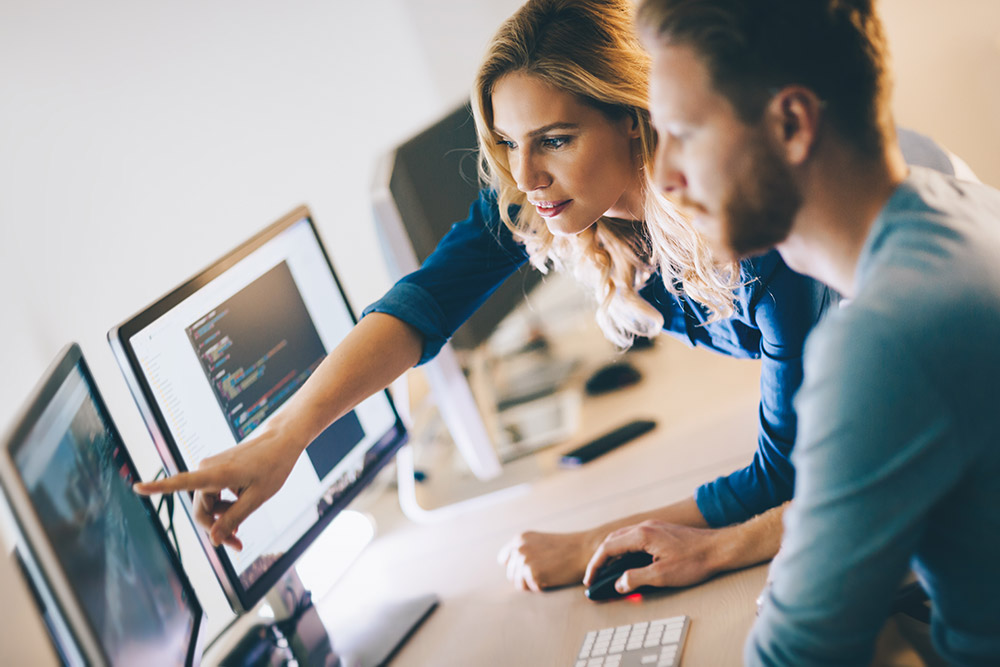 man and woman looking at computer