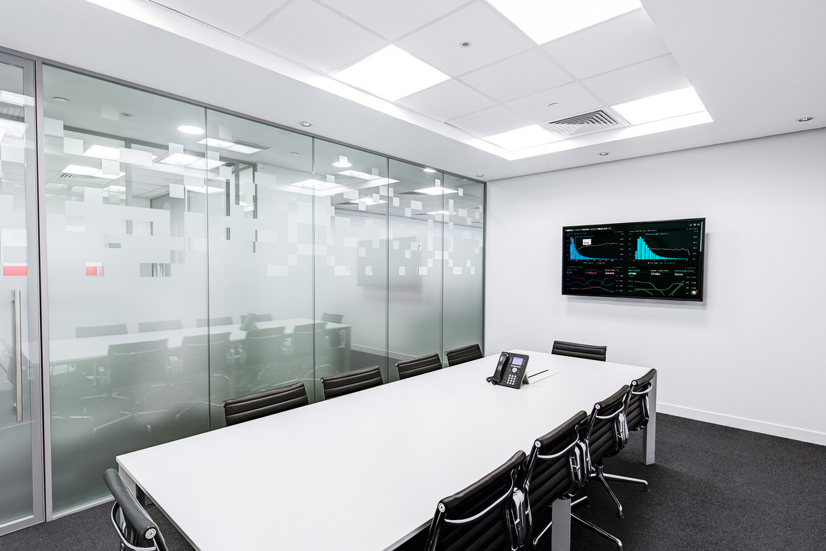 an empty meeting room with large commercial display on wall showing business charts and graphs