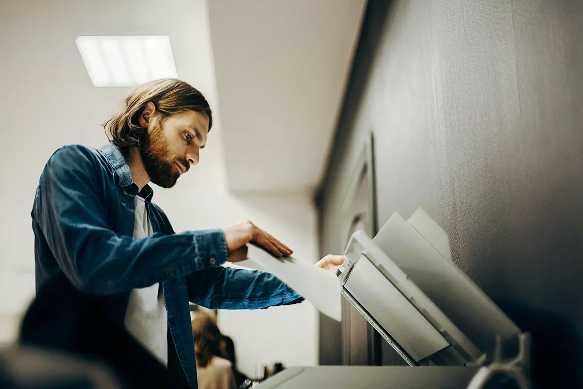choose-arrow-print-management Casually dressed male office worker using photocopier in office