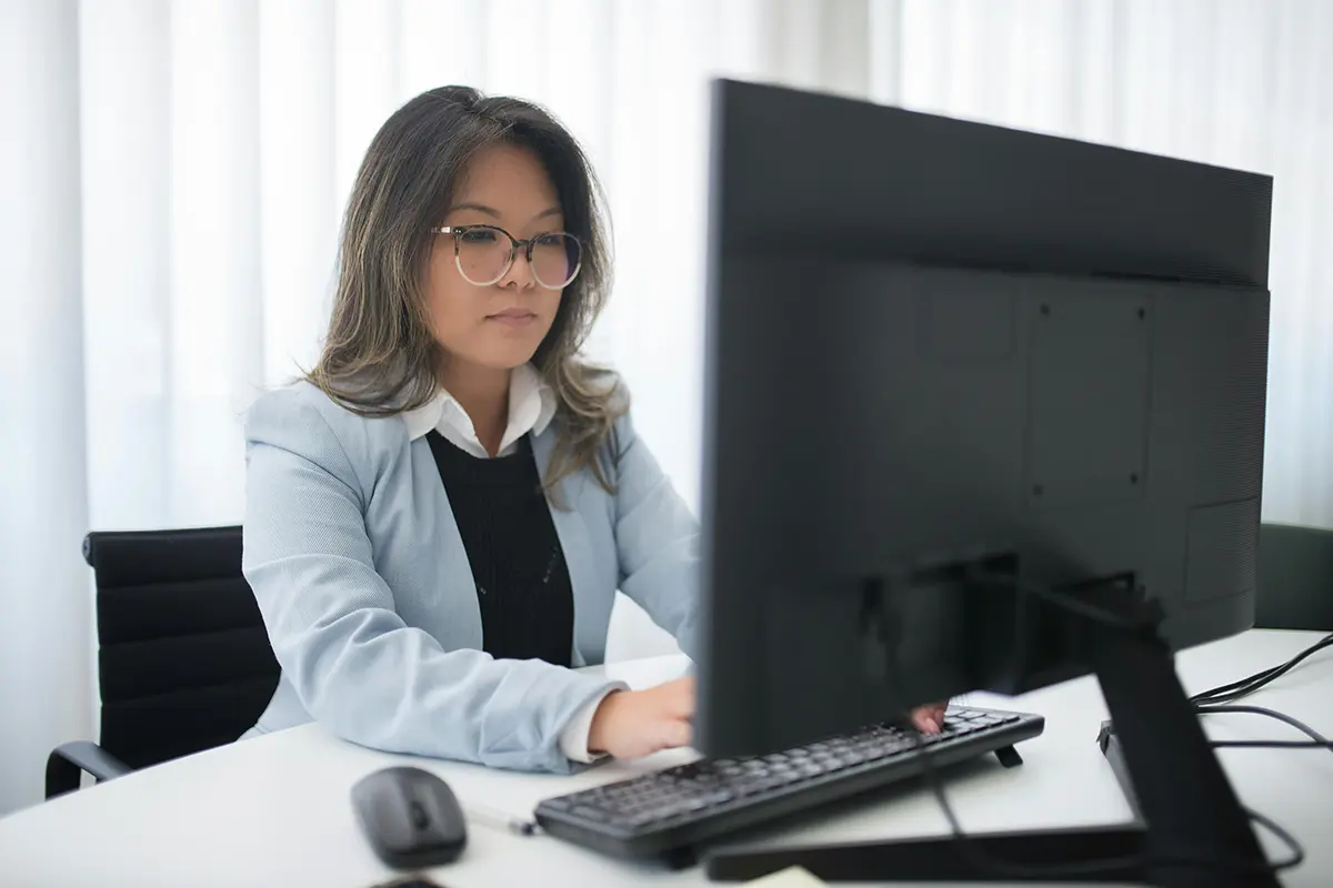 Female office worker using desktop PC