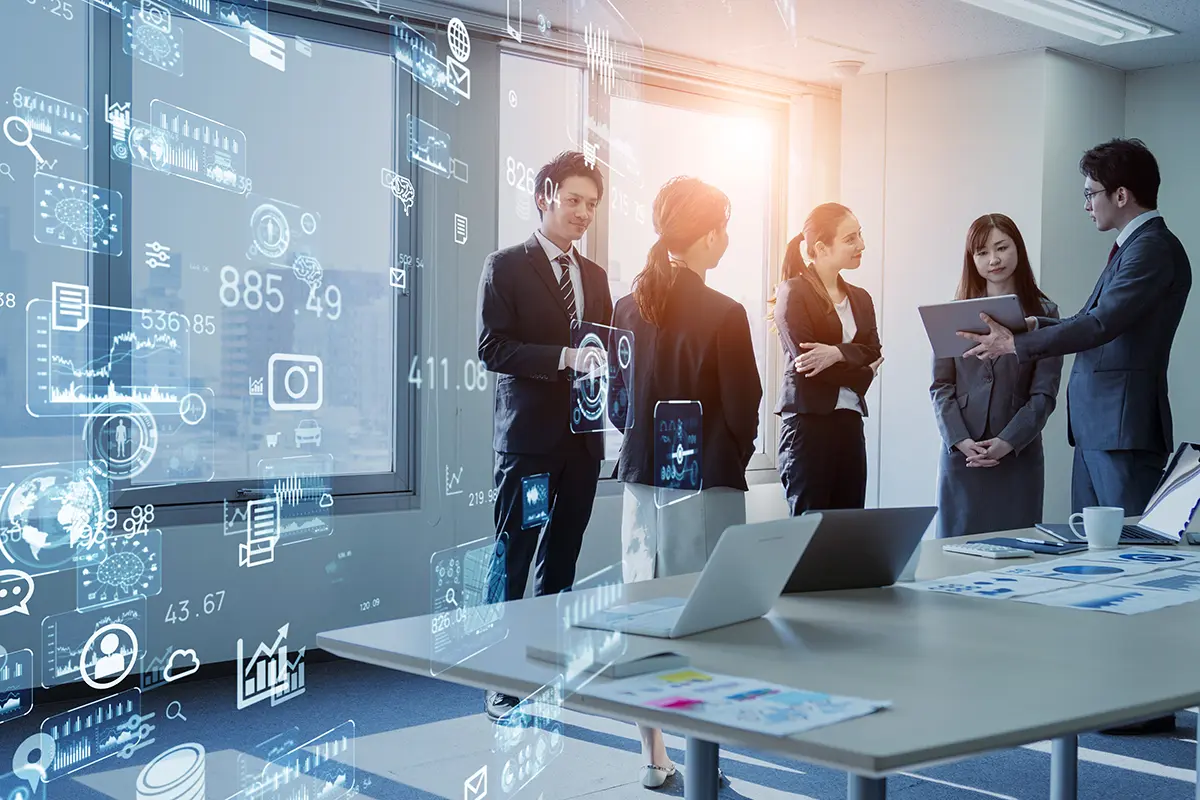 Tech-Trends_2026 Group of professionals in a modern office discussing business strategy, with digital graphics overlay showing cloud computing, analytics icons, and financial data points.